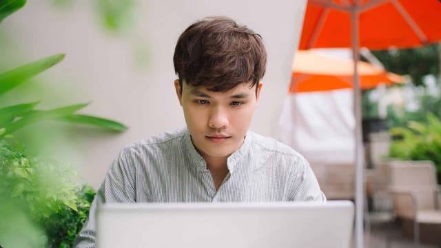 Person working on laptop outdoors.