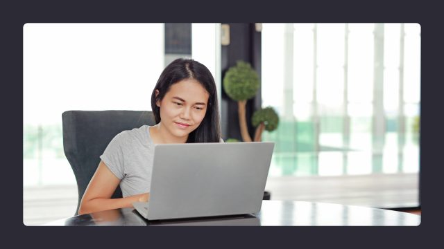 Woman working on laptop in bright office