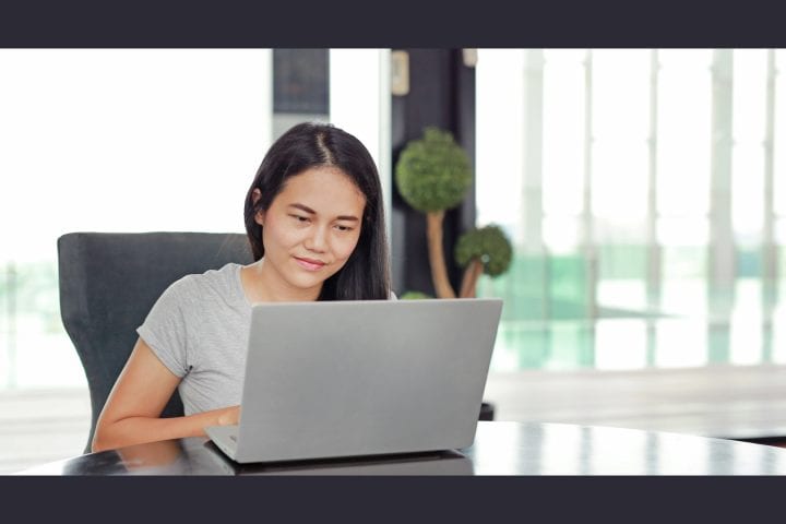 Woman working on laptop in bright office