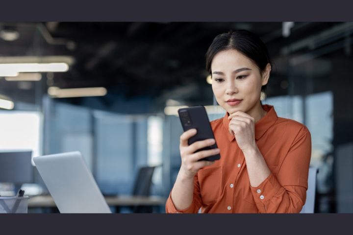 Woman checking phone in office