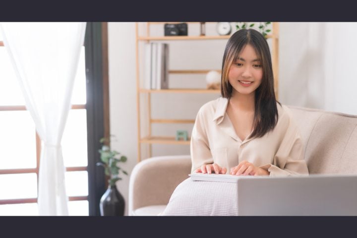 Woman working on laptop in bright home office