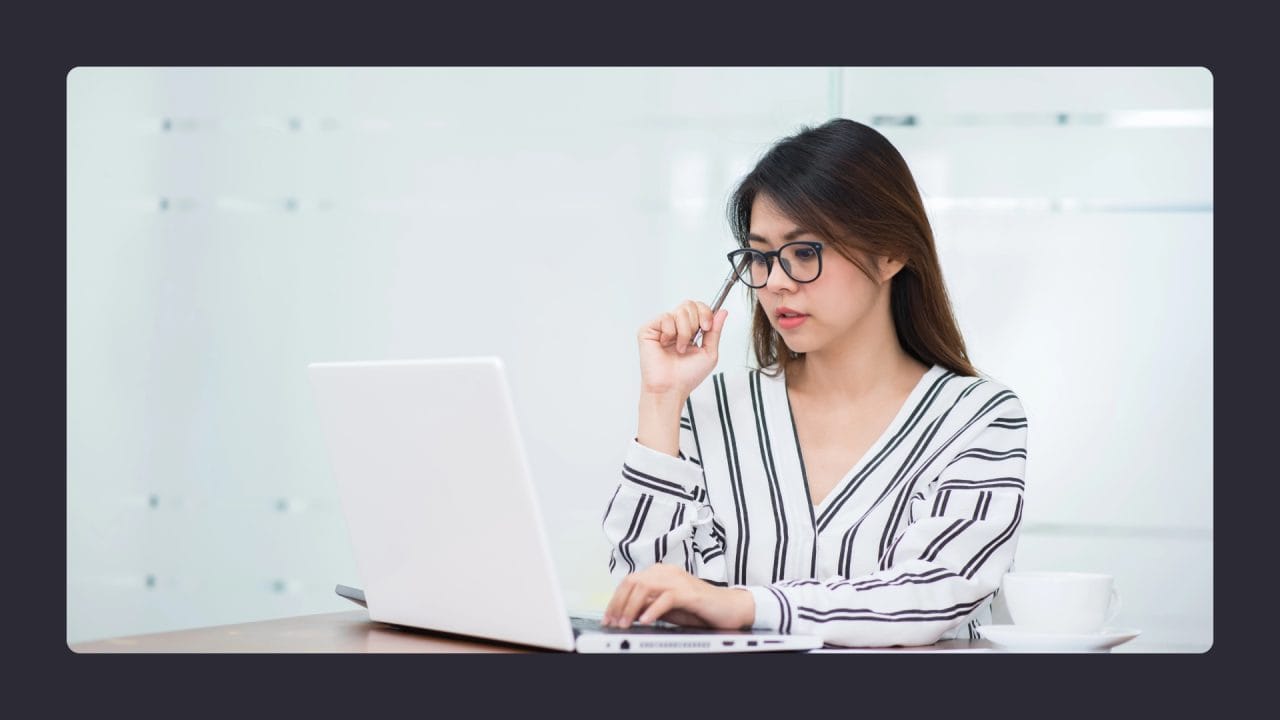 Focused woman using laptop in modern office