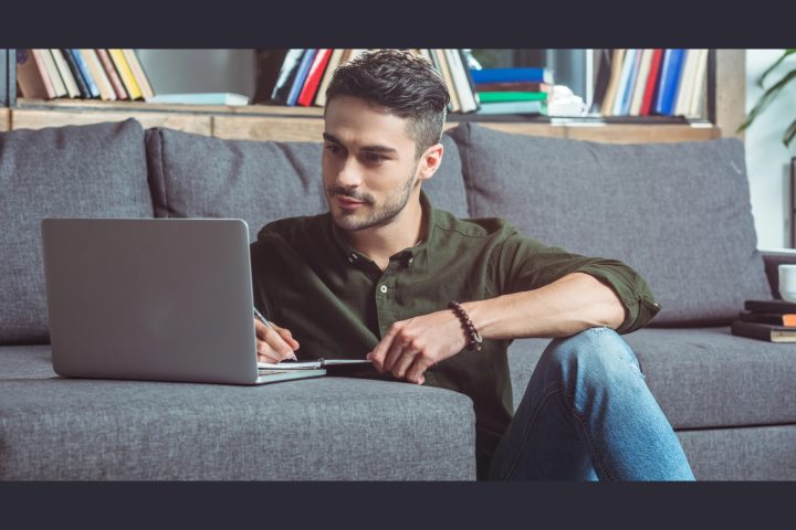 Man working on laptop while sitting on couch