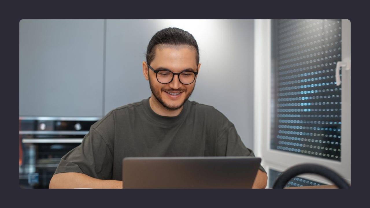 Smiling man using laptop in modern office