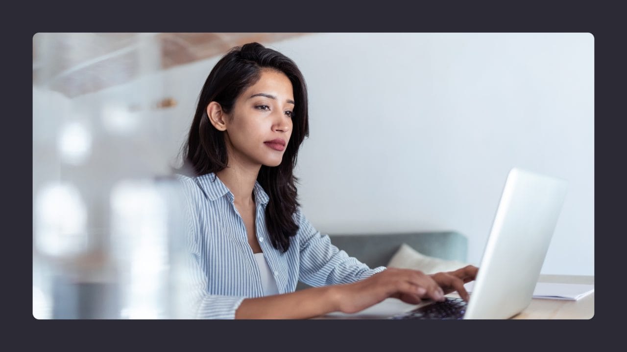 Focused woman working on laptop in modern office