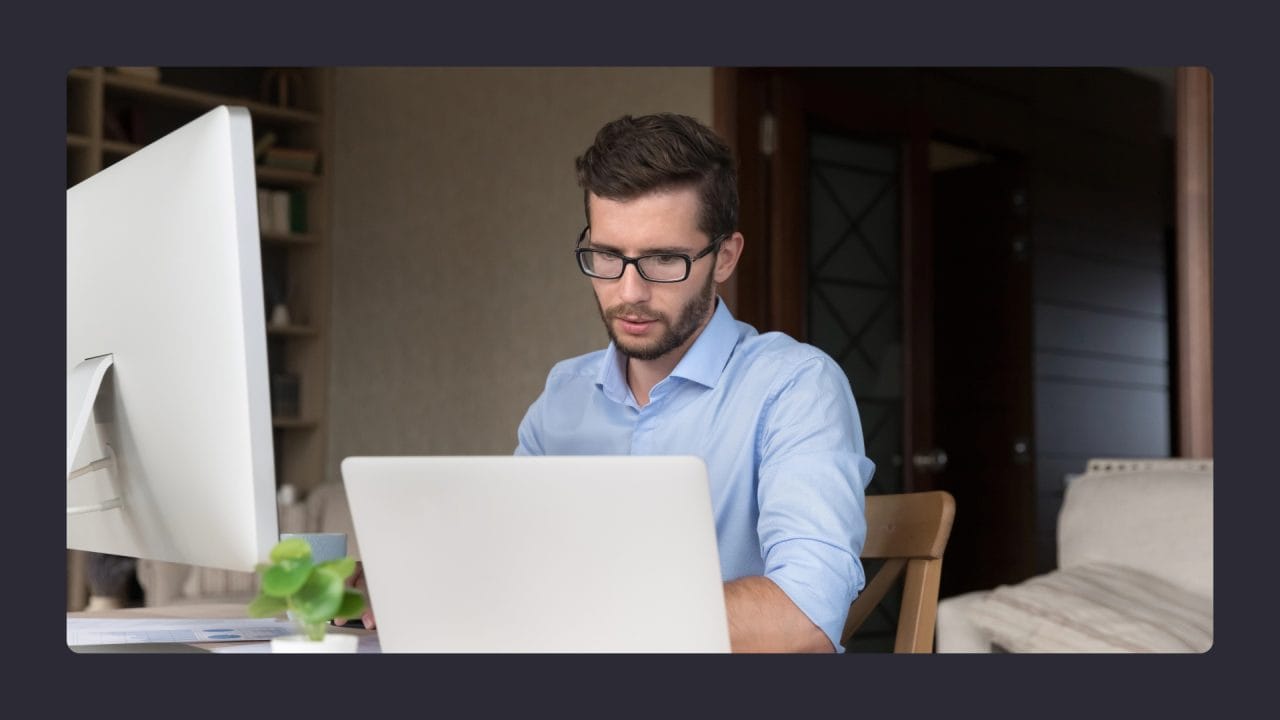 Focused man working on laptop in office setting