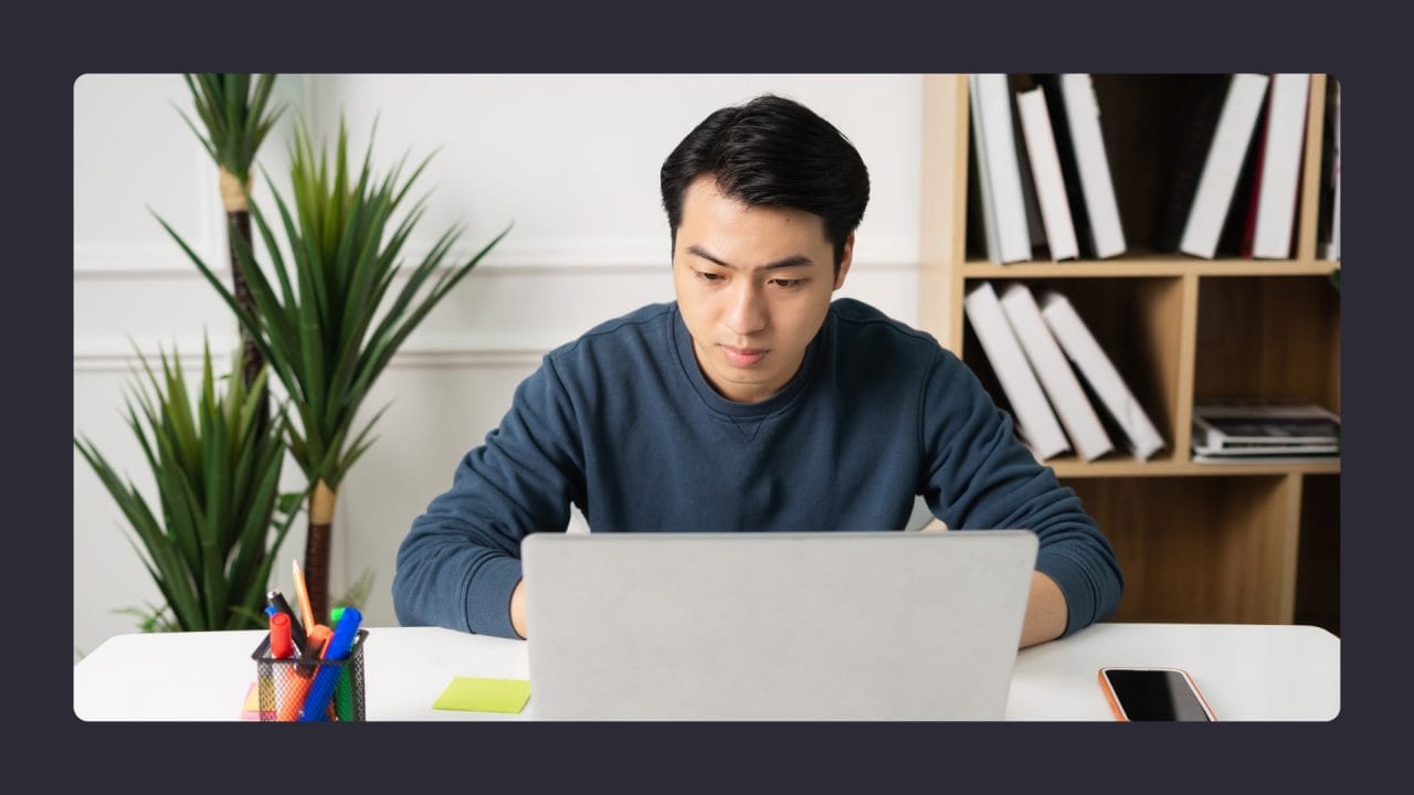 Focused Asian man working on laptop in office