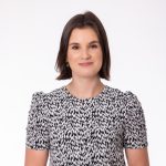 Confident woman in printed blouse smiling gently