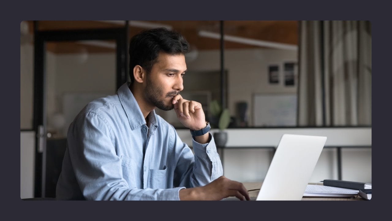 Focused man working on laptop in office setting