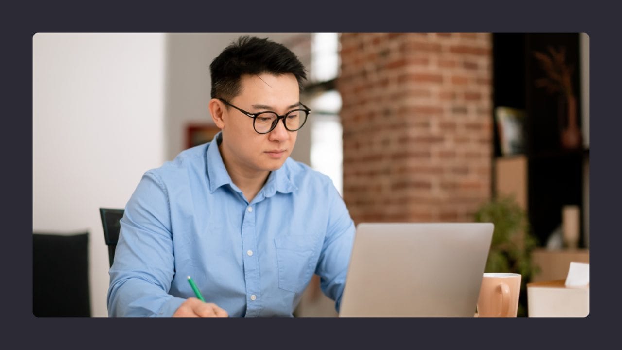 Young man working on laptop in modern office.