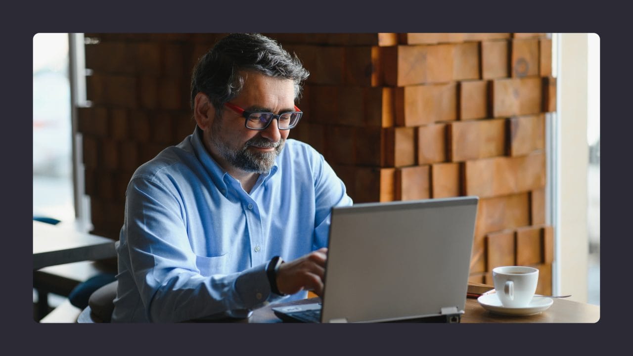 Man using laptop in cozy cafe with coffee