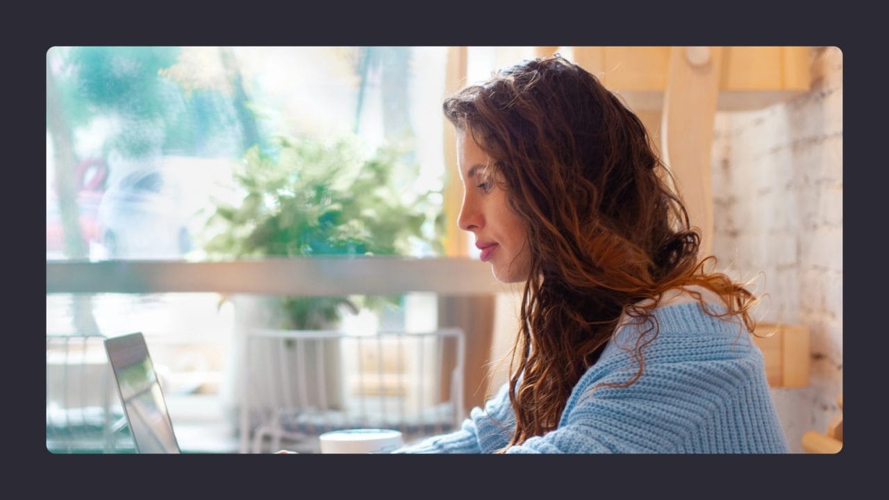 Woman using laptop in cozy cafe