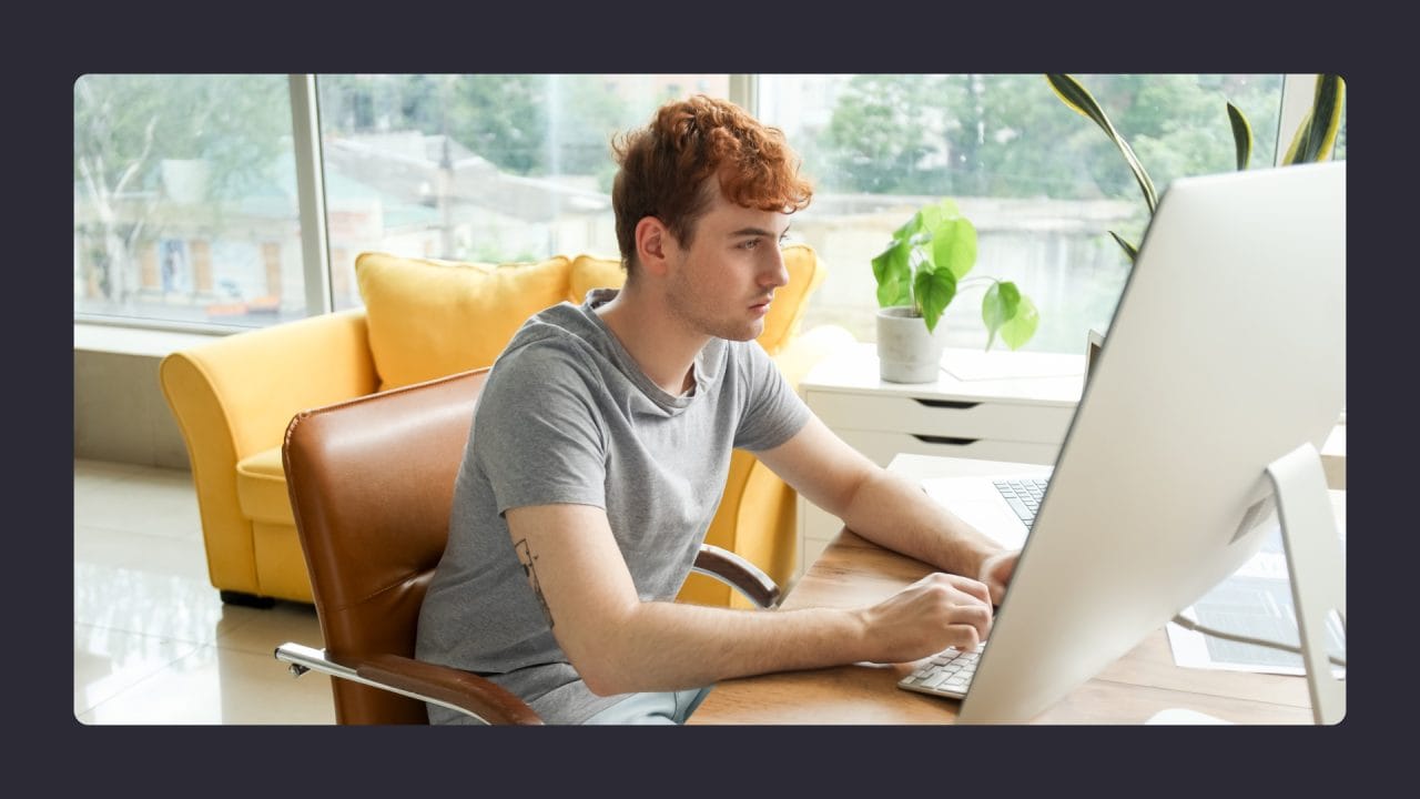 Young man working on laptop in bright home office